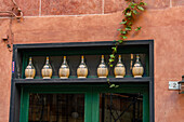 A row of fiascos or traditional wine bottles over a restaurant door in Monterosso al Mare, Cinque Terre, Italy.