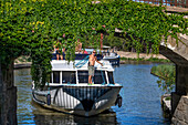 Boat crossing the Écluse de Puichéric look. Canal du Midi at village of Puichéric Carcassone Aude South of France southern waterway waterways holidaymakers queue for a boat trip on the river, France, Europe