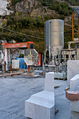 A shaped piece of marble & the diamond wire cutting machine at a marble studio in Carrara, Italy.