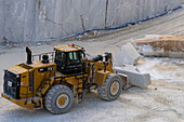 A front-end loader moves a marble block in a marble quarry in the Fantiscritti in Apuan Alps near Carrara, Italy.