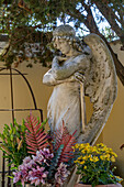 An angel statue on a grave in a cemetery in Anacapri on the island of Capri, Italy.