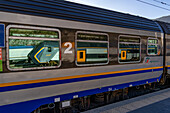 A Trenitalia Rock train reflected in the windows of a Pop regional passenger train in La Spezia, Italy. The Pop is a Coradia Stream built by Alstom.