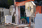 A block of marble being separated after being cut with a diamond wire cutter. Fantiscritti, Carrara, Italy. The cutter is at right.