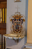 A commesso or marble mosaic over a holy water stoup in the Church of San Francesco di'Assisi in Sorrento, Italy.