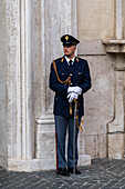 A policeman in ceremonial uniform guards the Chigi Palace on Piazza Colonna in Rome, Italy. The Chigi Palace is the seat of the Council of Ministers and official residence of the prime minister of Italy.