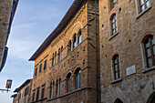 A medieval palace with Gothic architecture on Via San Matteo in the walled city of San Gimignano, Italy.