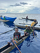 Residents of New Hanover island in their traditional dugout canoes, New Ireland province, Papua New Guinea