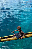 Residents of Tungelo Island in their traditional dugout canoes, New Ireland province, Papua New Guinea