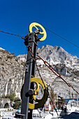 Vintage wheel & pulley system for cutting marble with diamond-coated wire. Fantiscritti Quarry Museum, Carrara, Italy. The quarries are visible on the mountain behind.