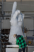 A sculptor uses a pneumatic chisel to carve a marble statue in a carving studio in Fantscritti, Carrara, Italy.