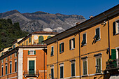 Die Apuanischen Alpen mit ihren Marmorbrüchen überblicken den Palazzo Diana auf der Piazza Alberica in Carrara, Italien.