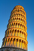 Moon rising by the Leaning Tower of Pisa, the campanile or bell tower of the Duomo or Cathedral of Pisa. Pisa, Italy.