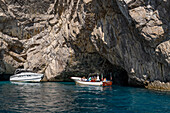 A small tour boat with passengers at the Green Grotto on the island of Capri, Italy.