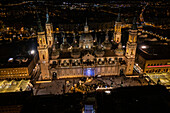 Aerial view of the Cathedral Basilica of of Our Lady of the Pillar and El Pilar square illuminated at night during Christmas, Zaragoza, Spain