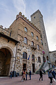 Facade & tower of the 13th Century Palazzo Comunale, Palazzo del Popolo or city hall in San Gimignano, Italy.