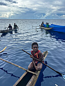 Residents of New Hanover island in their traditional dugout canoes, New Ireland province, Papua New Guinea