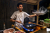 Waiter with a maldivian dish in the water restaurant of Six Senses Laamu maldives luxury resort villas, Laamu Atoll region Maldives