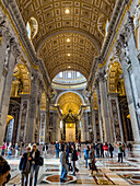 Visitors in the nave of St. Peter's Basilica, Vatican City, Rome, Italy.