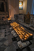 Votive candles on the side of the nave of the Duomo of Amalfi, the Cathedral of St. Andrew, Amalfi, Italy.