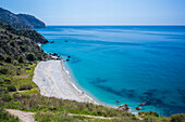 A scenic coastal view showcasing a pristine beach with clear blue water in Nerja.