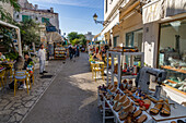 Visitors dining al fresco on a shopping street in Anacapri on the island of Capri, Italy.