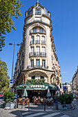 People sitting at Charivaryi cafe restaurant on a street avenue in Montparnasse Paris France EU Europe