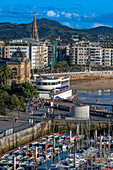 Playa de la Concha beach and fishing boats and sport fishing boats to recreational boat fishing are moored in the harbor of Donostia San Sebastian.