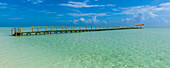 Blick auf einen Steg im türkisfarbenen Wasser vor dem Strand eines Badeortes in Cayo Guillermo; Cayo Guillermo, Kuba.