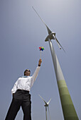 Geschäftsmann mit Windrad an Windturbine