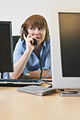 Frau plaudert am Telefon bei der Arbeit