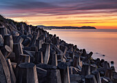 Sea Defences on Llanddulas Beach backed by The Great Orme at sunset, Llanddulas, near Abergele, Conwy County Borough, North Wales, United Kingdom, Europe