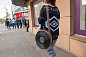 Young woman with eccentric handbag walking on Nicolae Balcescu Boulevard, Bucharest, Romania