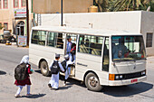 School children taking the school bus, Birkat Al Mouz in the Al Dakhliya region, foothills of Jebel Akhdar, Sultanate of Oman, Arabian Peninsula