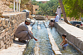 Bathers in irrigation canal, Birkat Al Mouz, Al Dakhliya region, Falaj irrigation system (Falaj Al-Khatmeen), UNESCO, Oman, Arabian Peninsula