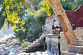 Junge Männer beim Baden in Al Thowarah (Nakhal Hot springs), Sultanat Oman, Arabische Halbinsel