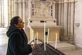 Woman holding a candle in Vezelay abbey, Sainte-Marie-Madeleine Basilica, Yonne, France