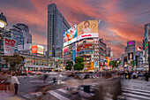 Blick auf Menschen an der belebtesten Straßenkreuzung der Welt, Shibuya Scramble Crossing bei Sonnenuntergang, Minato City, Tokio, Honshu, Japan