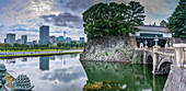 View of city skyline and Nijubashi bridge over the moat, The Imperial Palace of Tokyo, Tokyo, Honshu, Japan