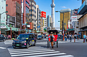 Ansicht einer japanischen Rikscha oder Jinrikisha in einer belebten Straßenszene, Asakusa, Taito City, Tokio, Honshu, Japan