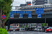 View of bullet train passing over bridge with city traffic, Minato City, Tokyo, Honshu, Japan