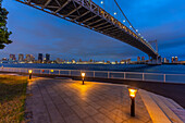 Blick auf die Regenbogenbrücke und Koto City im Hintergrund in der Abenddämmerung, Minato City, Tokio, Honshu, Japan