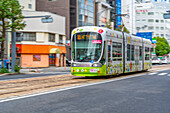 View of city tram on major street during daytime, Hondori, Naka Ward, Hiroshima, Honshu, Japan