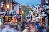 View of busy street and traditional wooden houses and shops in Gion, Kyoto Geisha District, Kyoto, Honshu, Japan