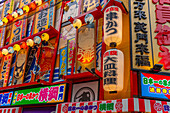 View of colourful facades of shops and restaurants in Dotonbori, vibrant entertainment district near the river, Osaka, Honshu, Japan