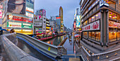 View of colourful adverts in Dotonbori, vibrant entertainment district near the river at dusk, Osaka, Honshu, Japan