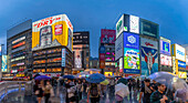 View of Glico sign of Dotonbori, vibrant entertainment district near the river at dusk, Osaka, Honshu, Japan