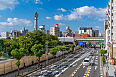 Blick auf den Tsutenkaku-Turm und die Skyline der Stadt an einem sonnigen Tag im Shinsekai-Gebiet, Osaka, Honshu, Japan