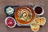 Indian chicken curry with sambal, naan and side dishes