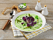 Cream of green asparagus soup with red onion rose