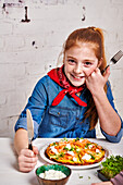 Girl eats courgette omelette with smoked salmon and cress